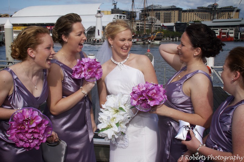bride and bridesmaids laughing - wedding photography